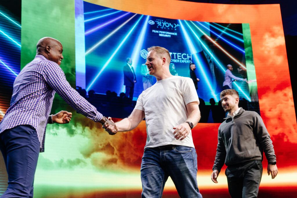 Ian and Jordon on stage shaking hands with the people presenting the awards